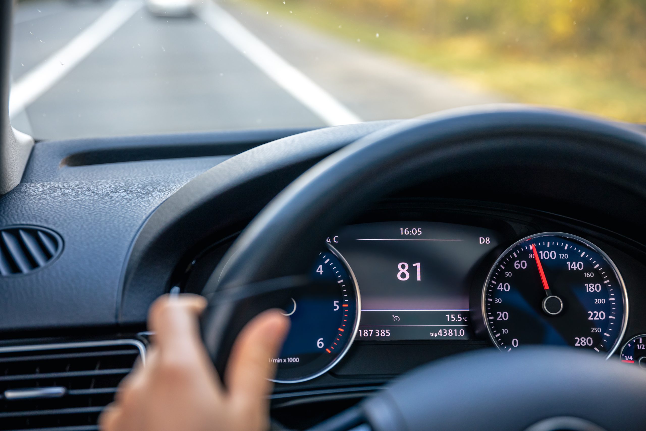 Steering wheel in a car close up, high speed driving on the road.